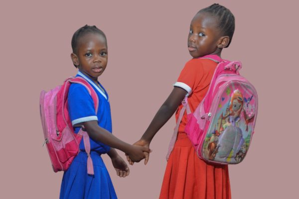 Two school children holding hands.